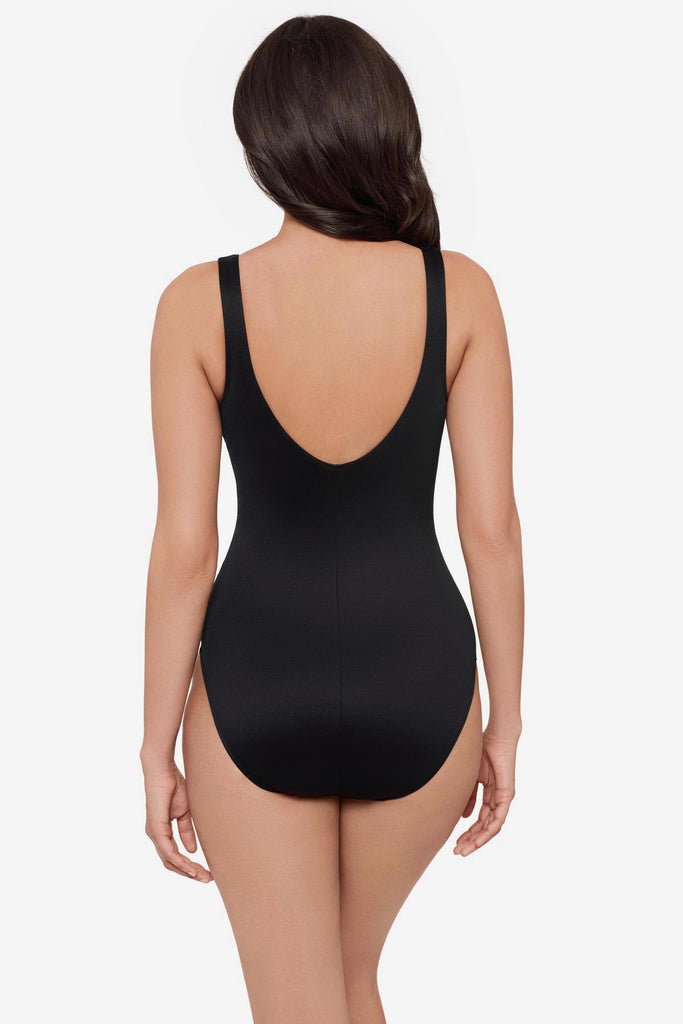 Woman turned away wearing a black one-piece swimsuit 