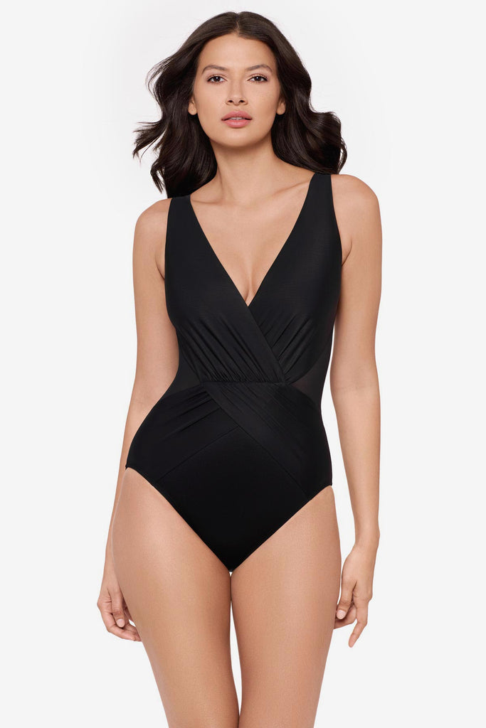 Woman wearing a black one-piece swimsuit with a V neckline