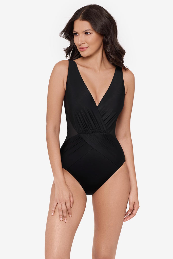 Woman wearing a black one-piece swimsuit with a V neckline