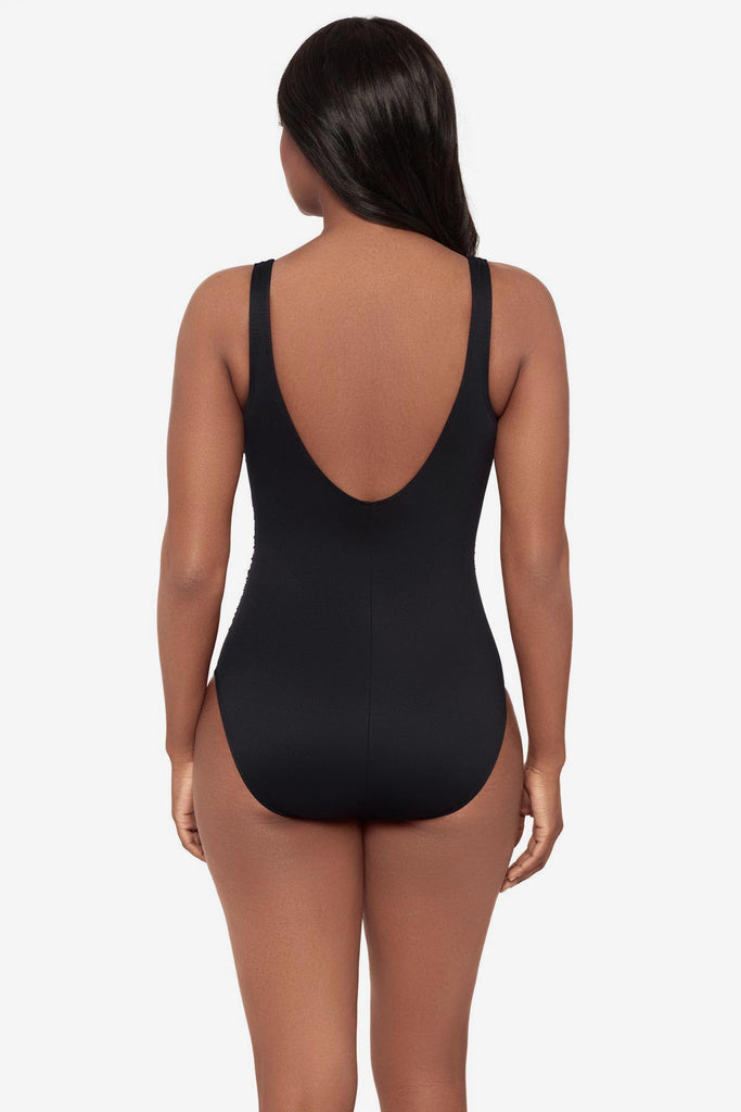 Woman turned away wearing a black one-piece swimsuit 