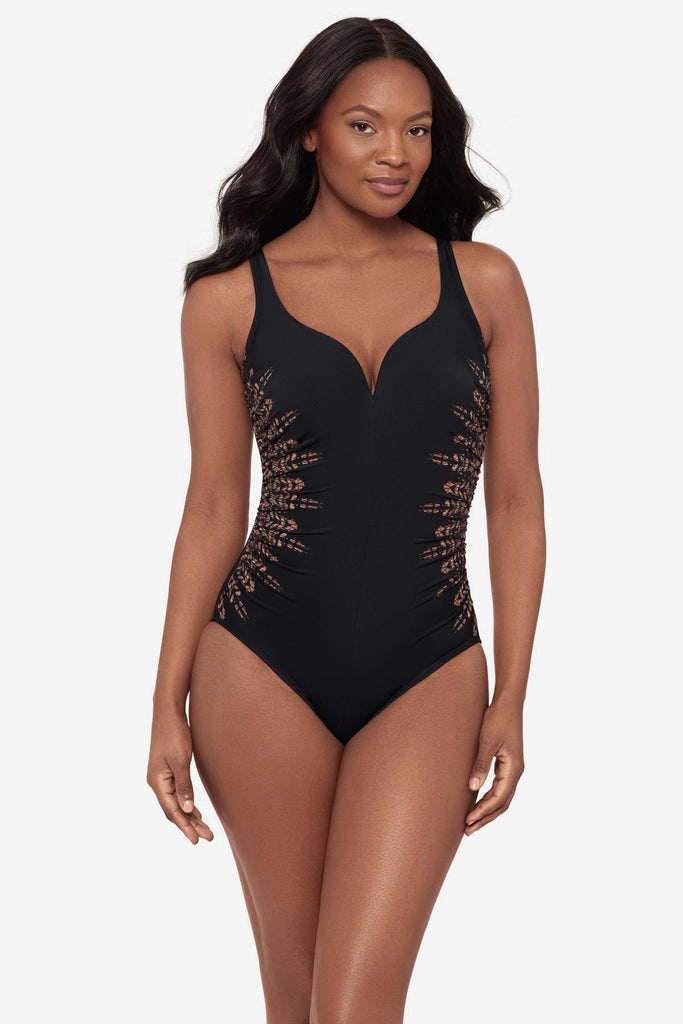 Woman wearing a black one-piece swimsuit with brown streaking on each side