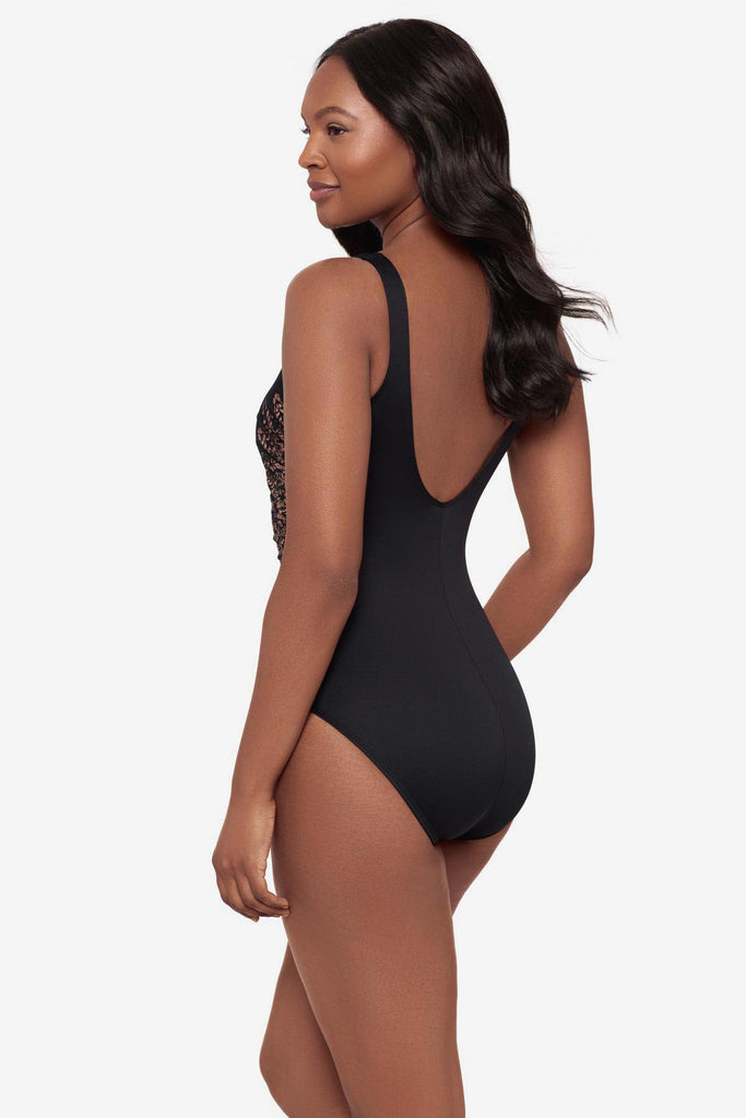 Woman turned left wearing a black one-piece swimsuit with brown streaking on each side