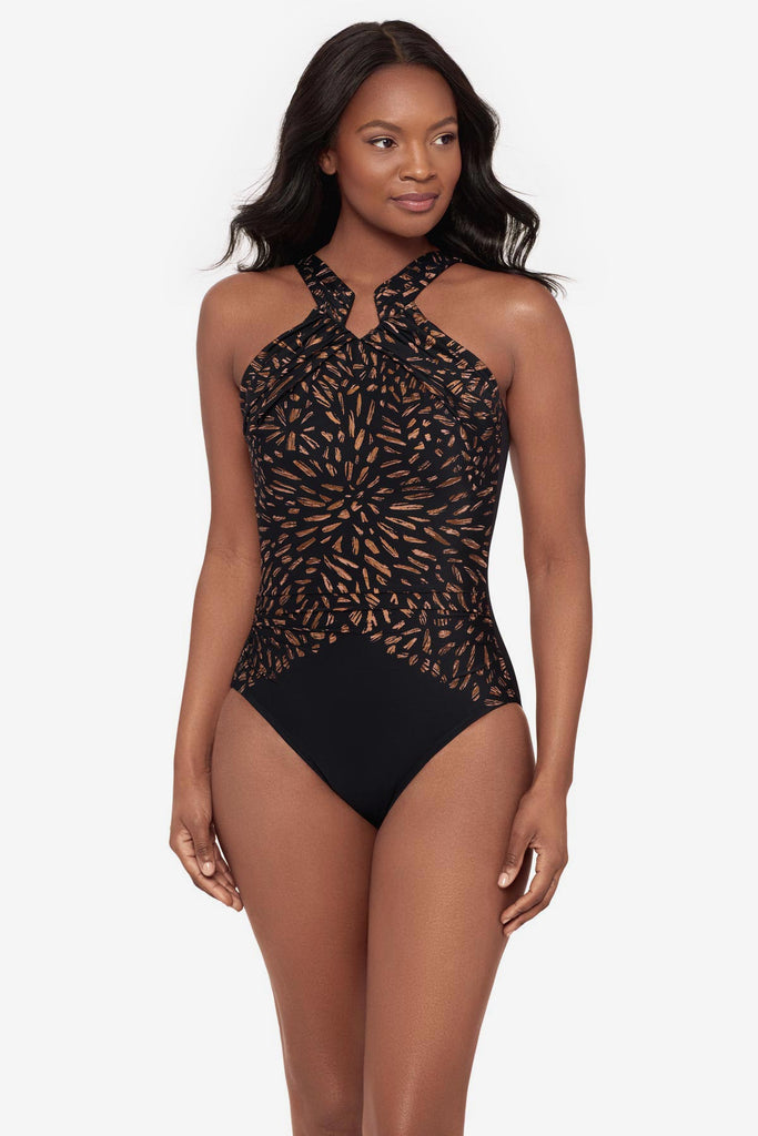 Woman wearing a black and brown printed one-piece swimsuit with a high neckline