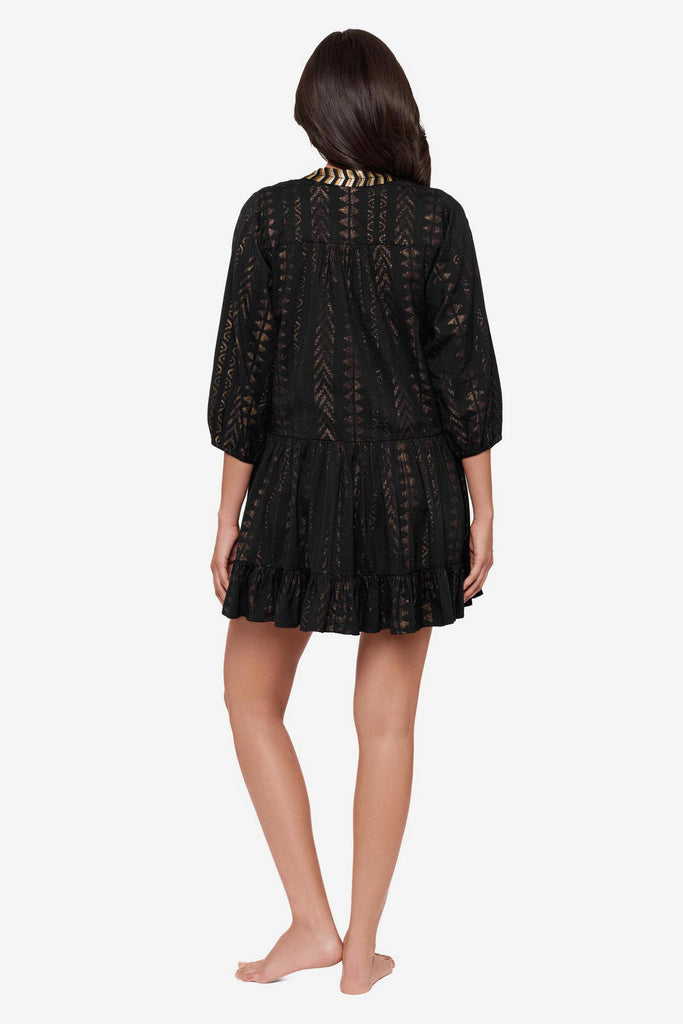 Woman turned away wearing a black pull-over kimono swim dress 