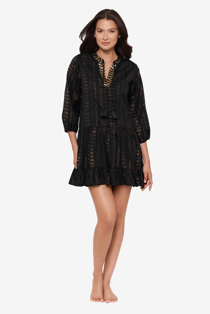 Woman wearing a black pull-over kimono swim dress with gold detailing on the front