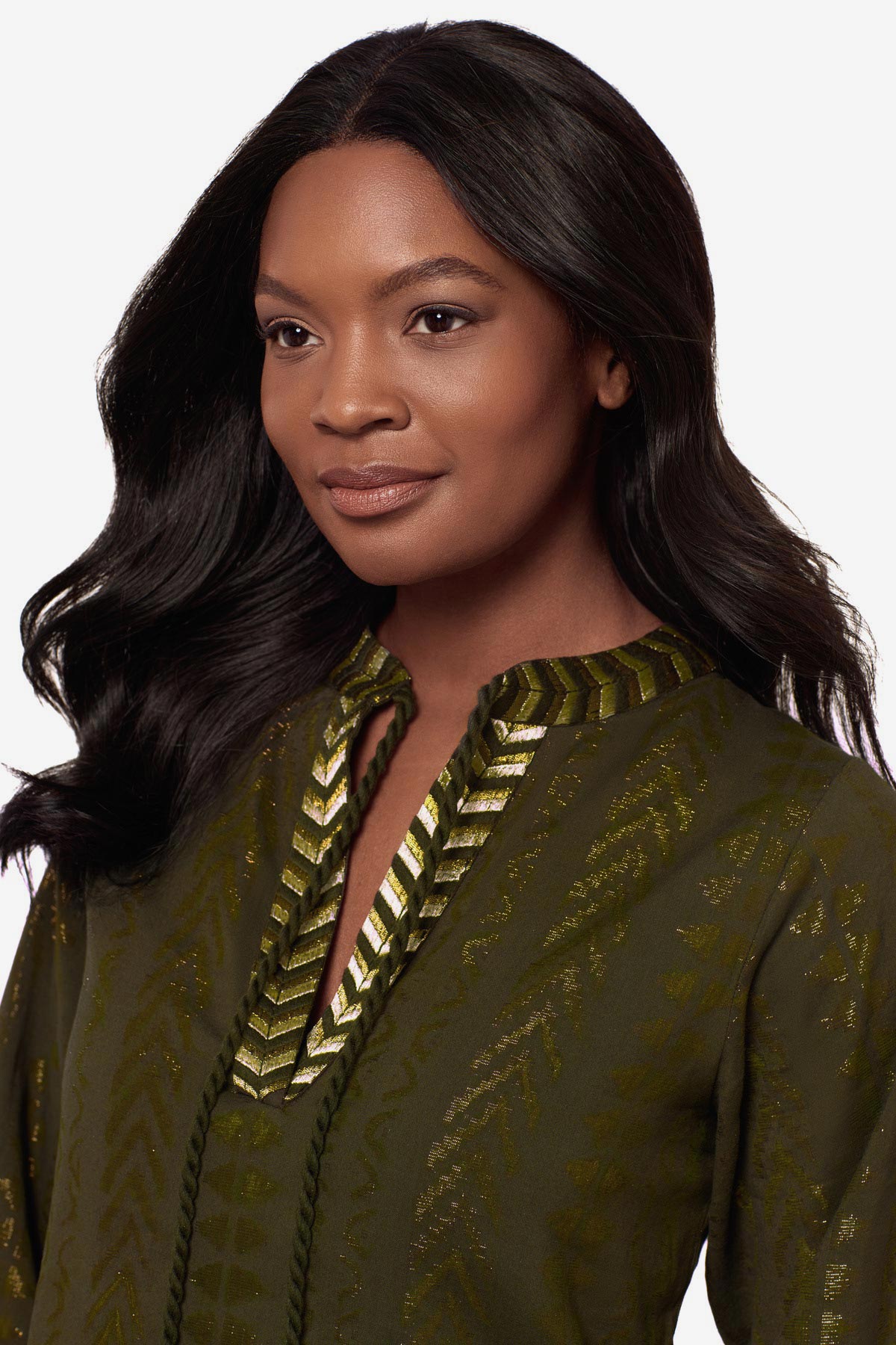 Close up of woman wearing a green pull-over kimono swim dress with gold detailing on the front