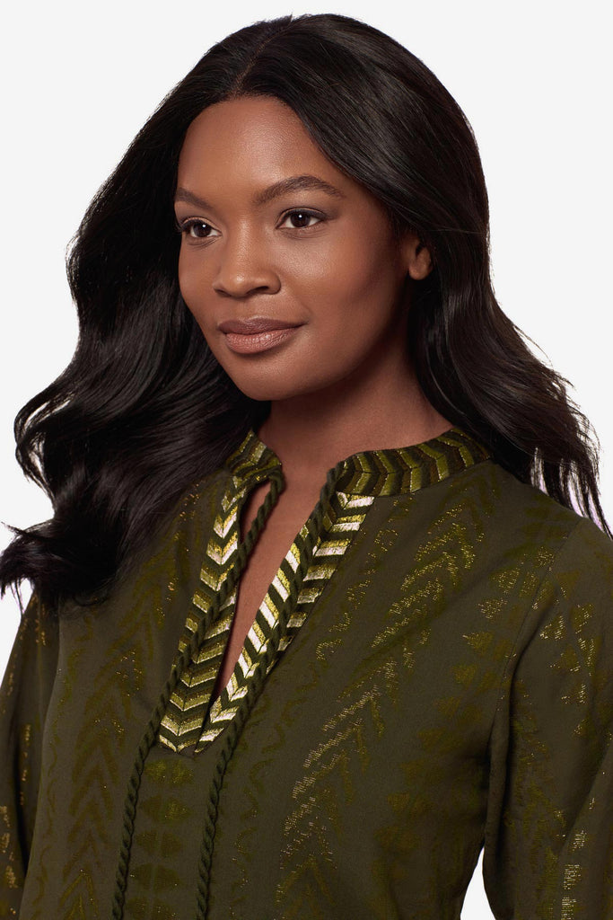 Close up of woman wearing a green pull-over kimono swim dress with gold detailing on the front