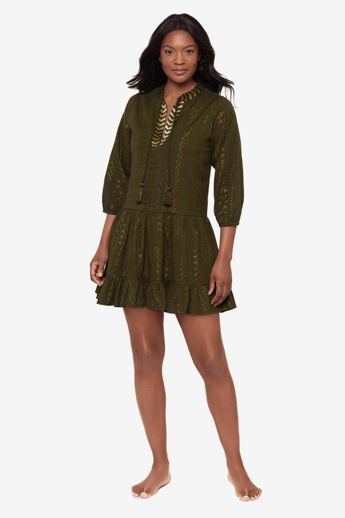 Woman wearing a green pull-over kimono swim dress with gold detailing on the front
