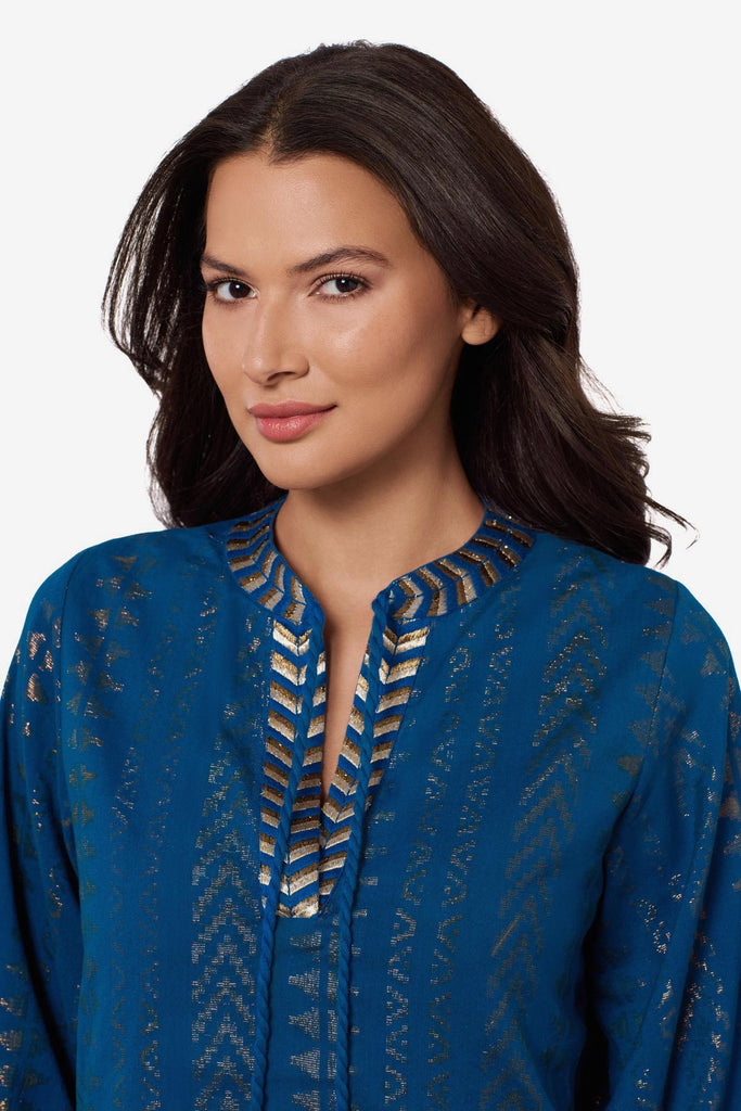 Close up of woman wearing a blue pull-over kimono swim dress with gold detailing on the front