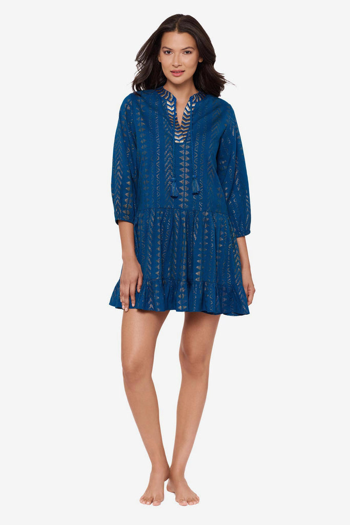 Woman wearing a blue pull-over kimono swim dress with gold detailing on the front