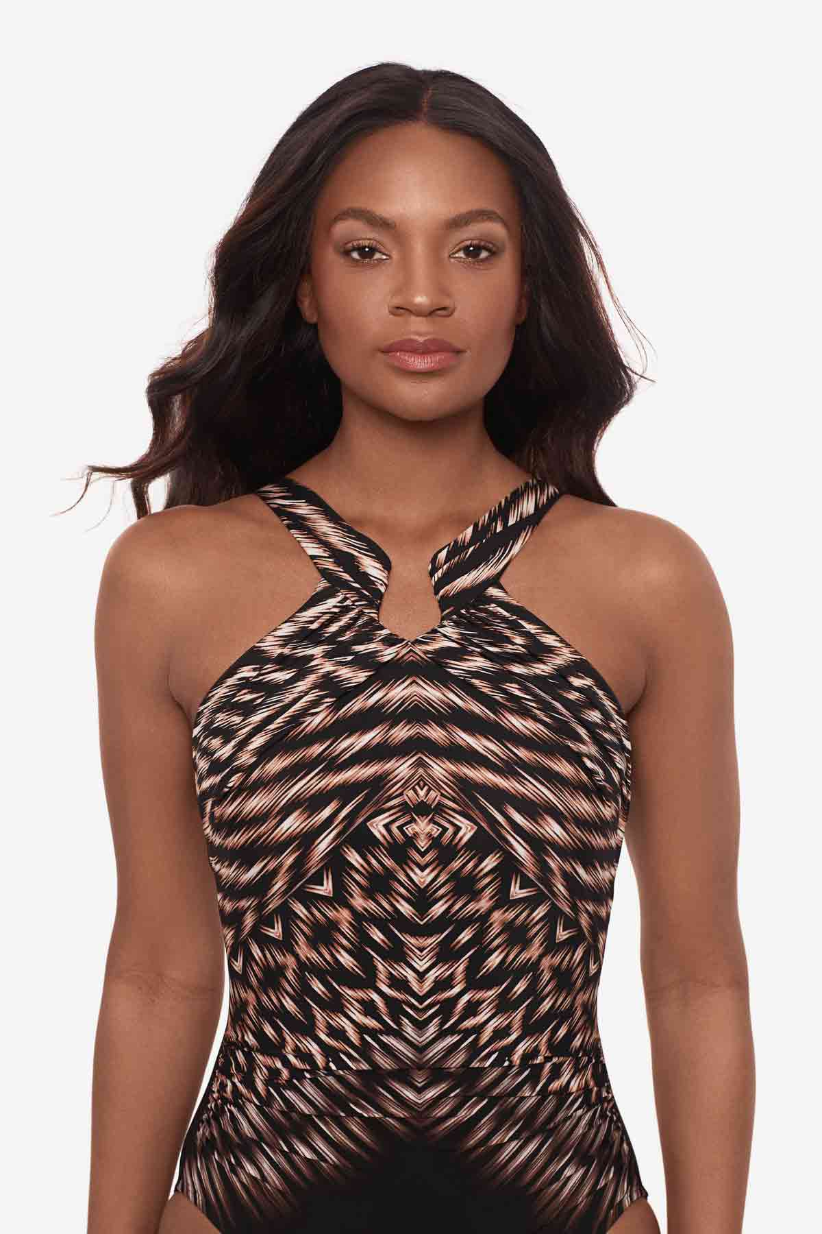 Close up of woman wearing a one-piece swimsuit with a multicolor pattern and high neckline