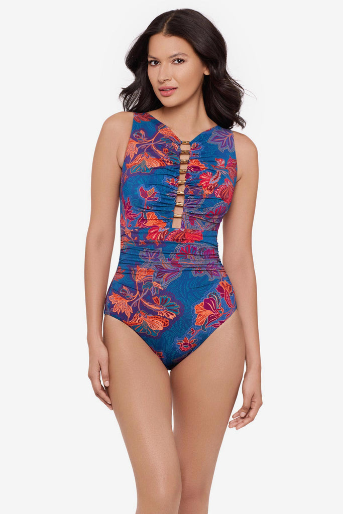 Woman wearing a multicolor one-piece swimsuit with embellishments down the front