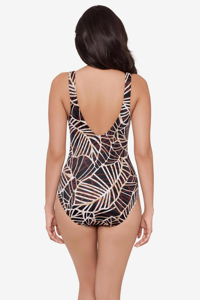 Woman turned away wearing a brown abstract printed one-piece swimsuit 