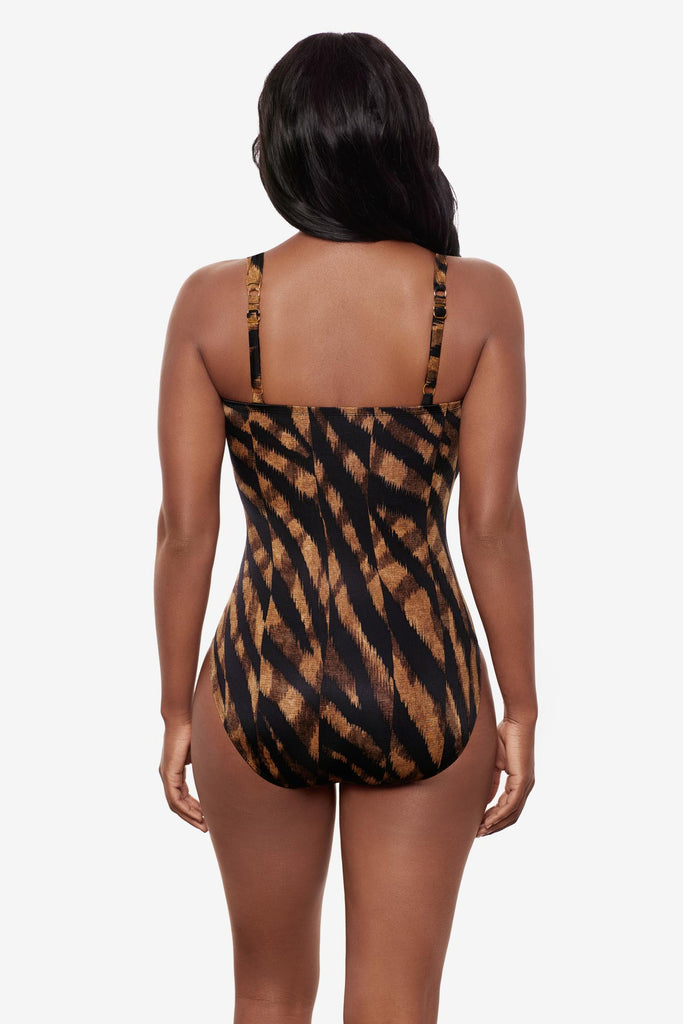 Woman turned away wearing a black and brown printed one-piece swimsuit