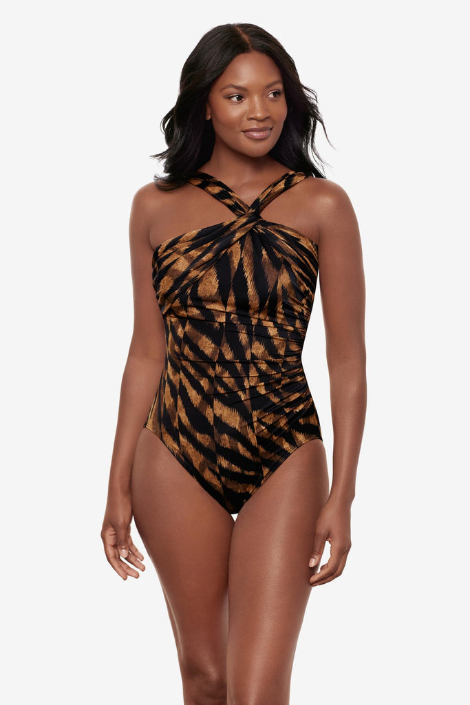 Woman wearing a black and brown printed one-piece swimsuit with a halter tie