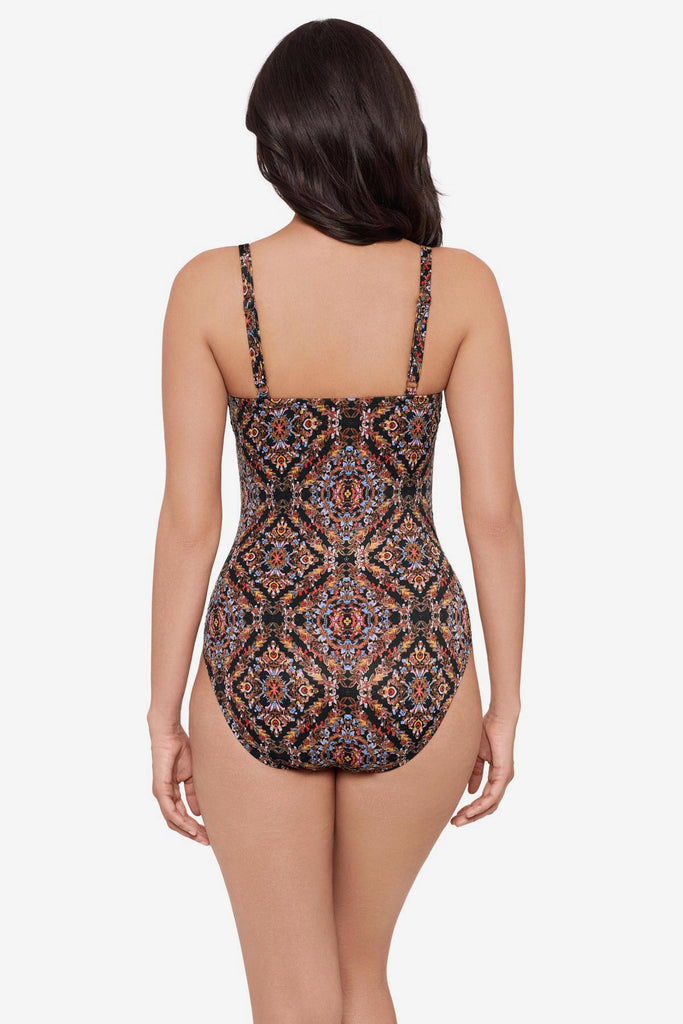Woman turned away wearing a multicolor abstract one-piece swimsuit