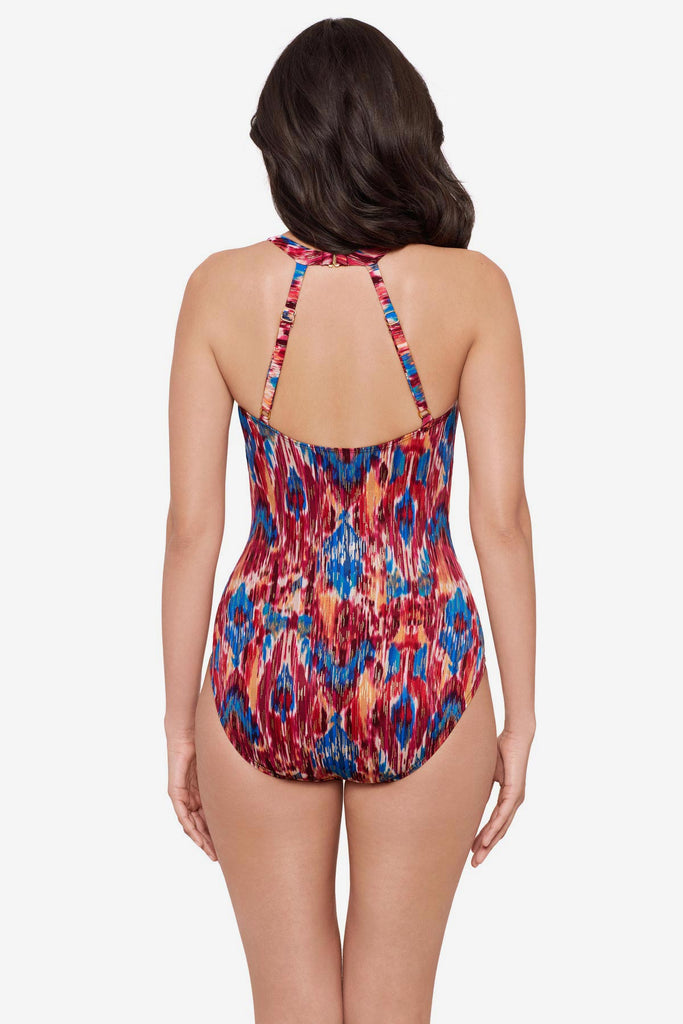 Woman turned away wearing a multicolored one-piece swimsuit with a strappy back