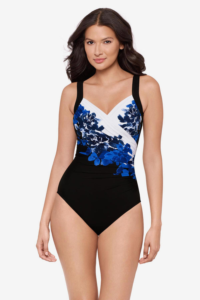 Woman wearing a blue floral print one-piece swimsuit with a V neckline