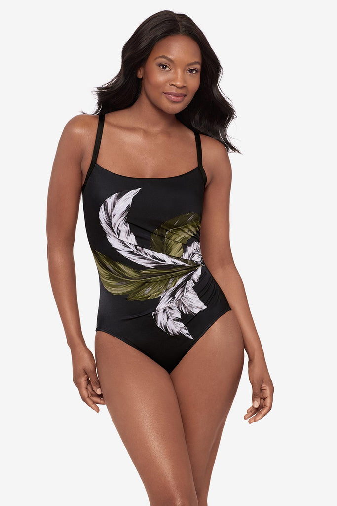 Woman wearing a green and white feather printed one-piece swimsuit