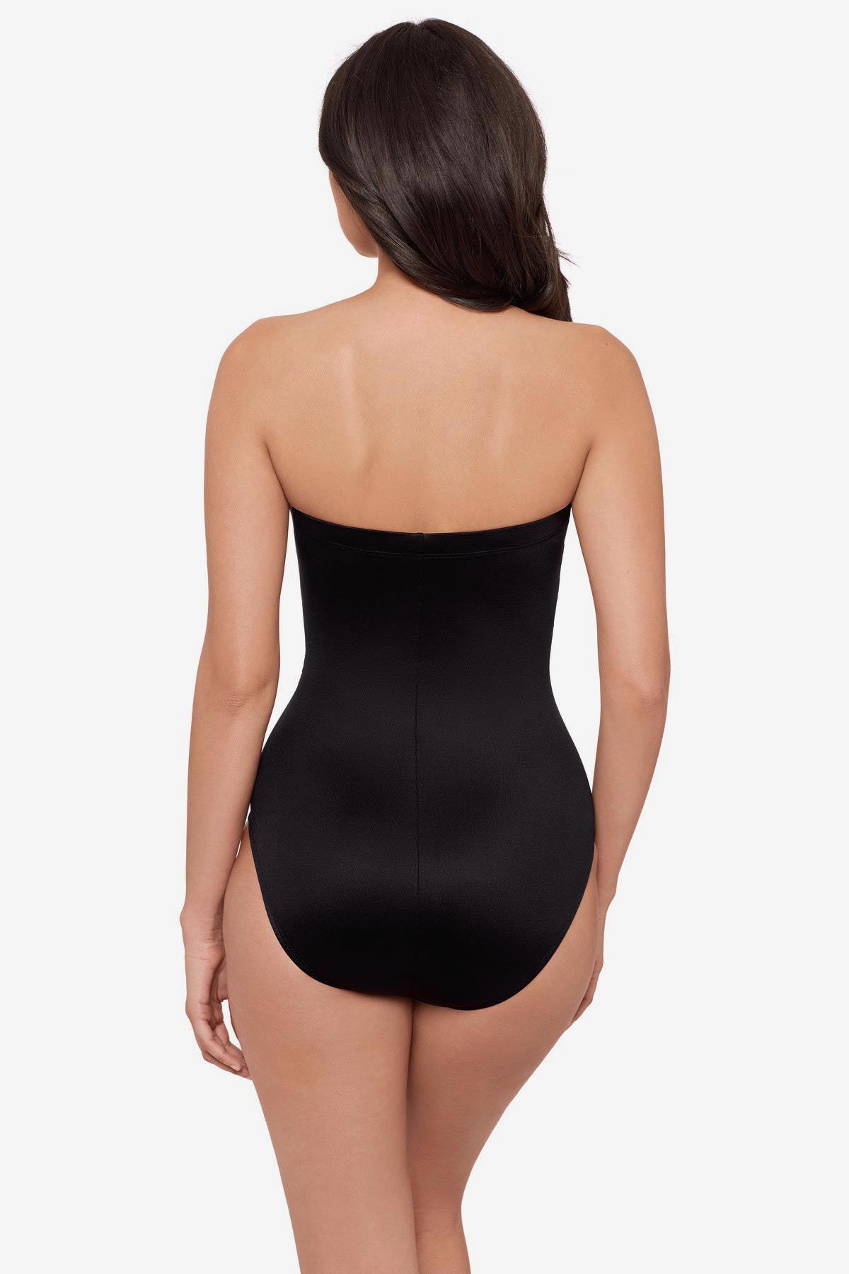 Woman turned away wearing a strapless green and white feather printed one-piece swimsuit