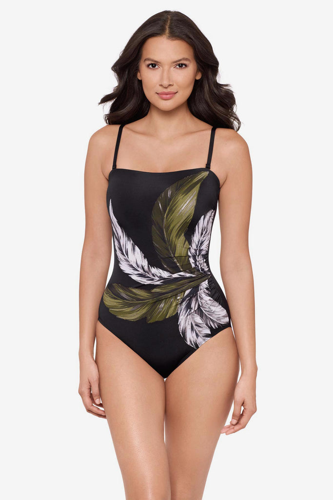 Woman wearing a green and white feather printed one-piece swimsuit
