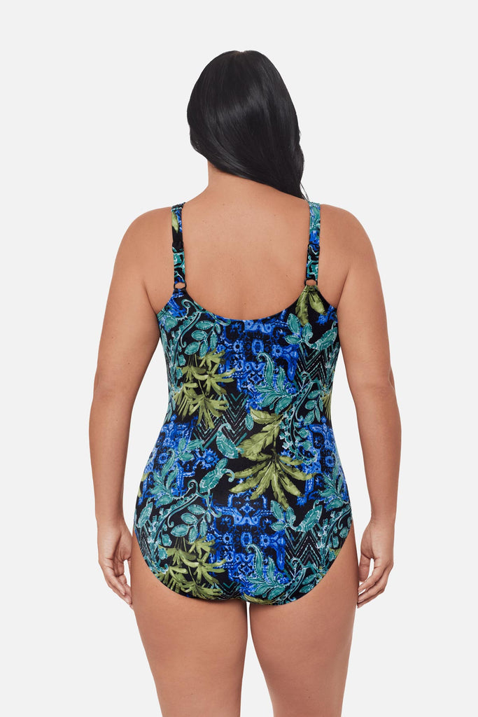 Woman turned away wearing a blue and green abstract printed one-piece swimsuit