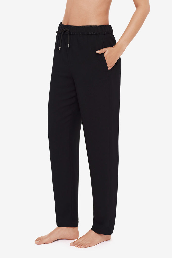 Close up of woman's legs in black jogger pants turned left