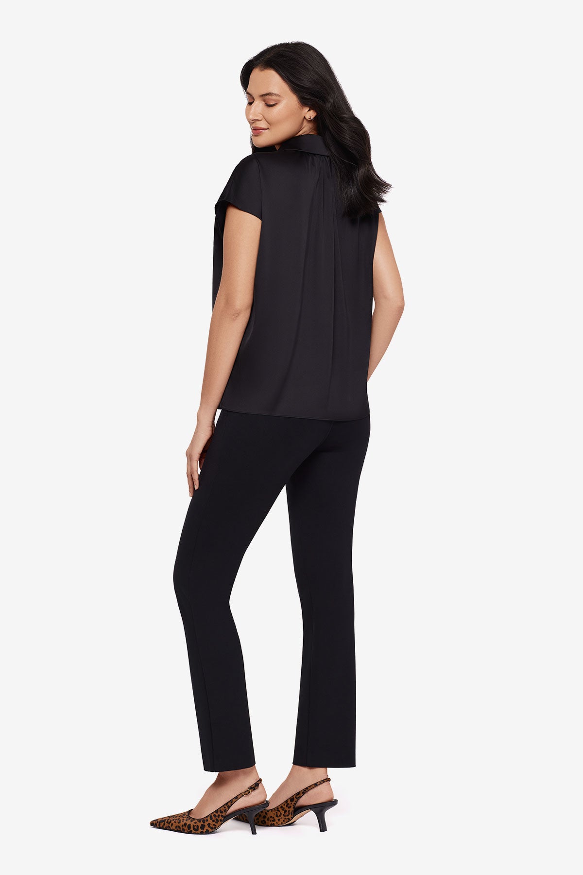 Woman turned left wearing a black button-down blouse with short sleeves with matching black pants
