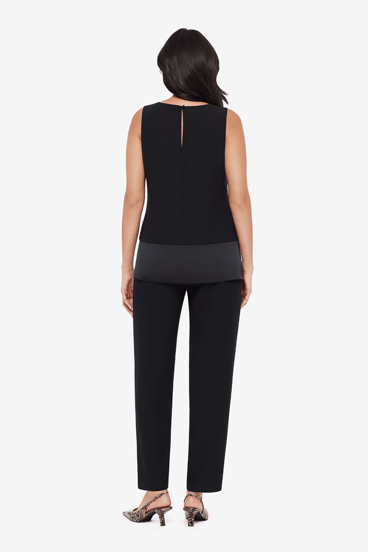 Woman turned away wearing a black layered tunic top with matching jogger pants
