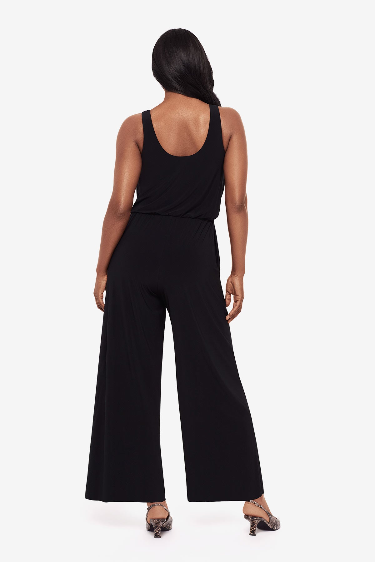 Woman turned away wearing an all black jumpsuit