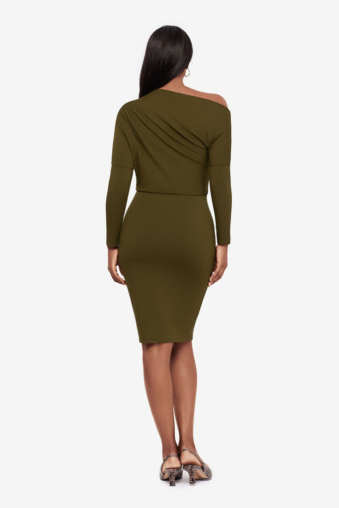 Woman turned away wearing a green long sleeve dress at knee length 