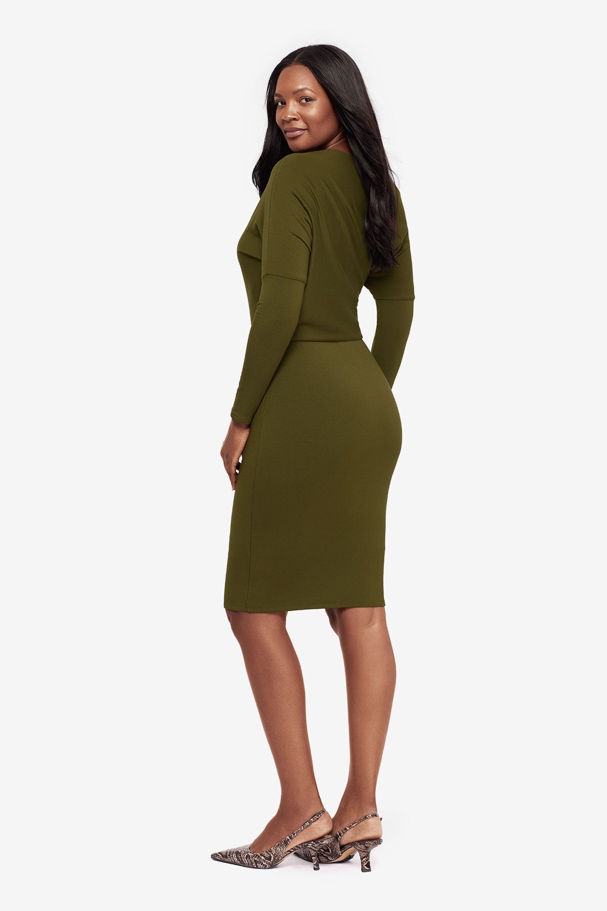 Woman turned left wearing a green long sleeve dress at knee length