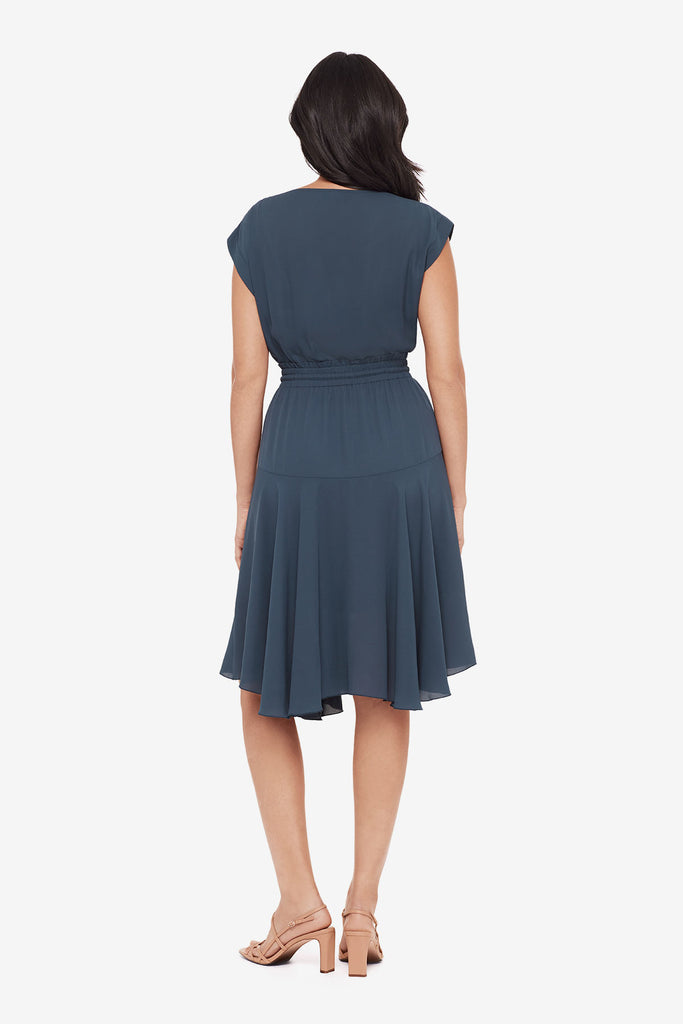 Woman turned away wearing a blue short sleeve dress with a drawstring feature