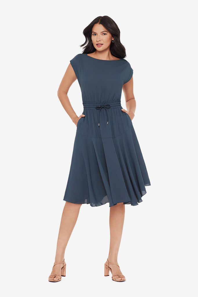 Woman wearing a blue short sleeve dress with a drawstring feature