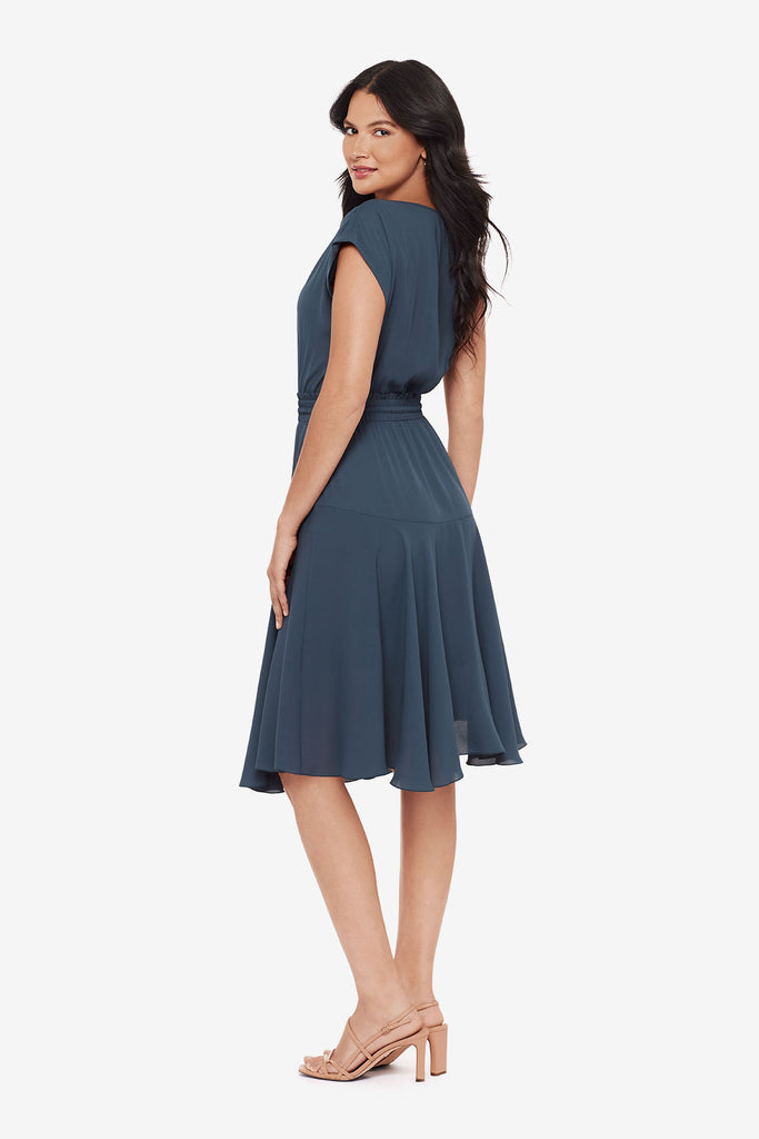 Woman turned left wearing a blue short sleeve dress with a drawstring feature
