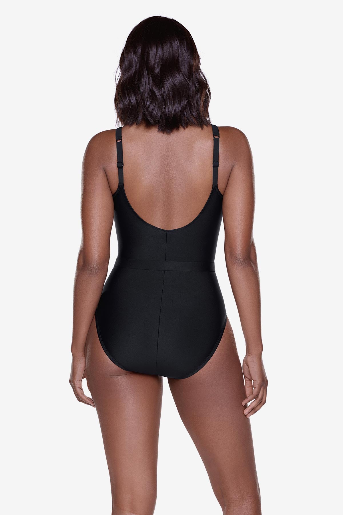 Woman turned away wearing a black one-piece swimsuit with belt detail