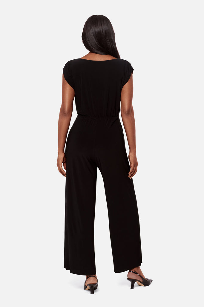 Woman turned away wearing a black short sleeve romper