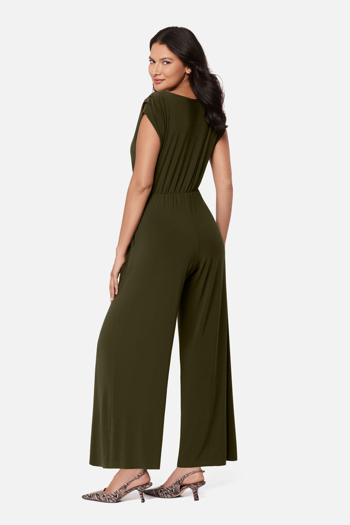 Woman turned left wearing a green romper with a sash around the waist