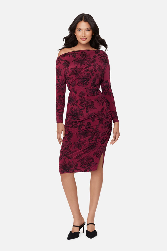 Woman wearing a maroon long sleeve dress with a floral pattern