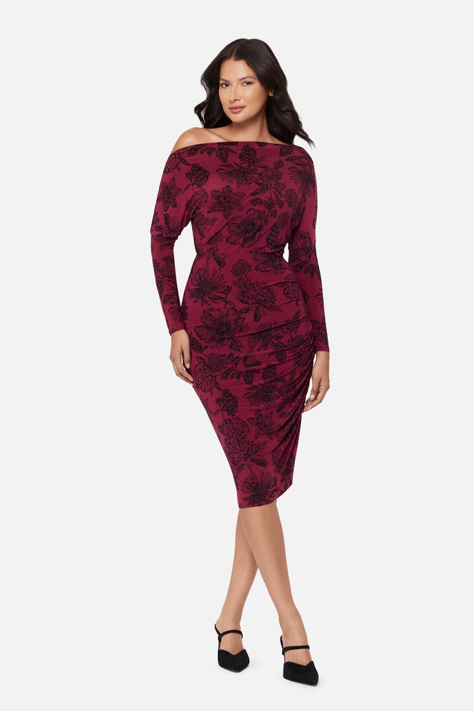 Woman wearing a maroon long sleeve dress with a floral pattern
