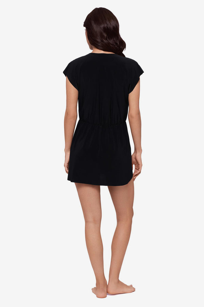 Woman faced away wearing a black swim dress cover up with short sleeves