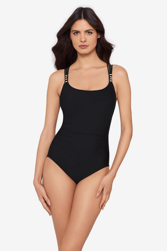 Woman wearing a black one-piece swimsuit with beads on the straps