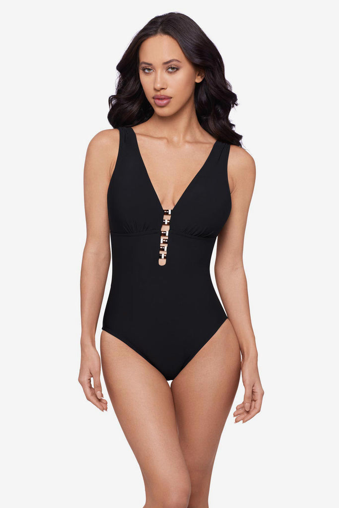 Woman wearing a black one-piece swimsuit with beading down the front