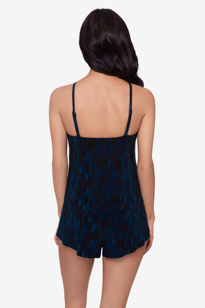 Woman turned away wearing a green tie-dyed swim romper