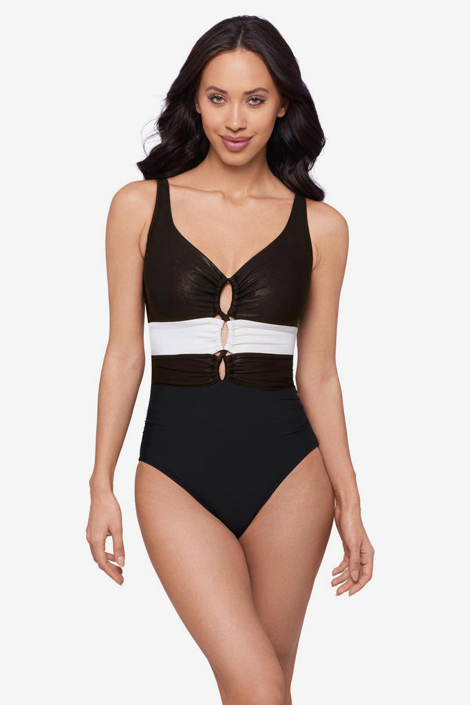 Woman wearing a black one-piece swimsuit with a white stripe in the middle