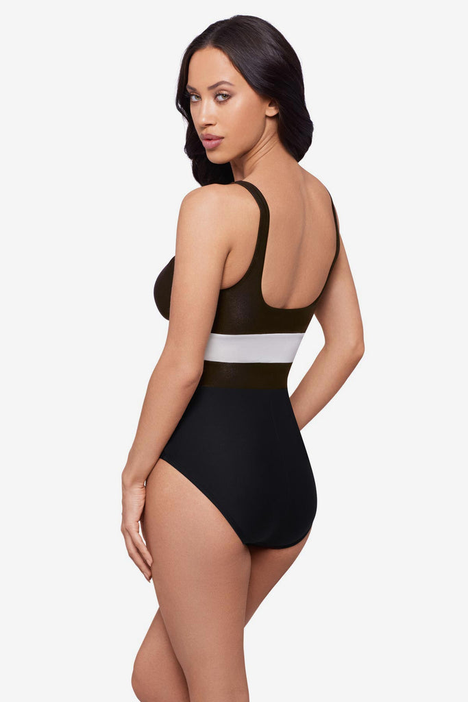 Woman turned left wearing a black one-piece swimsuit with a white stripe in the middle