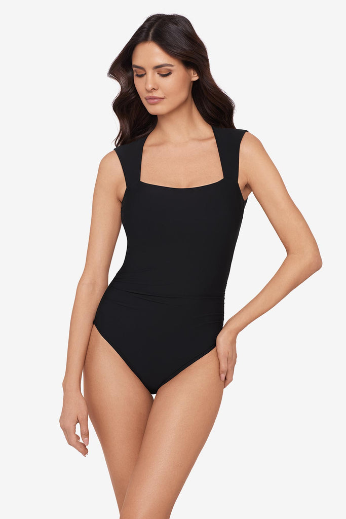 Woman wearing a black one-piece swimsuit with short sleeves