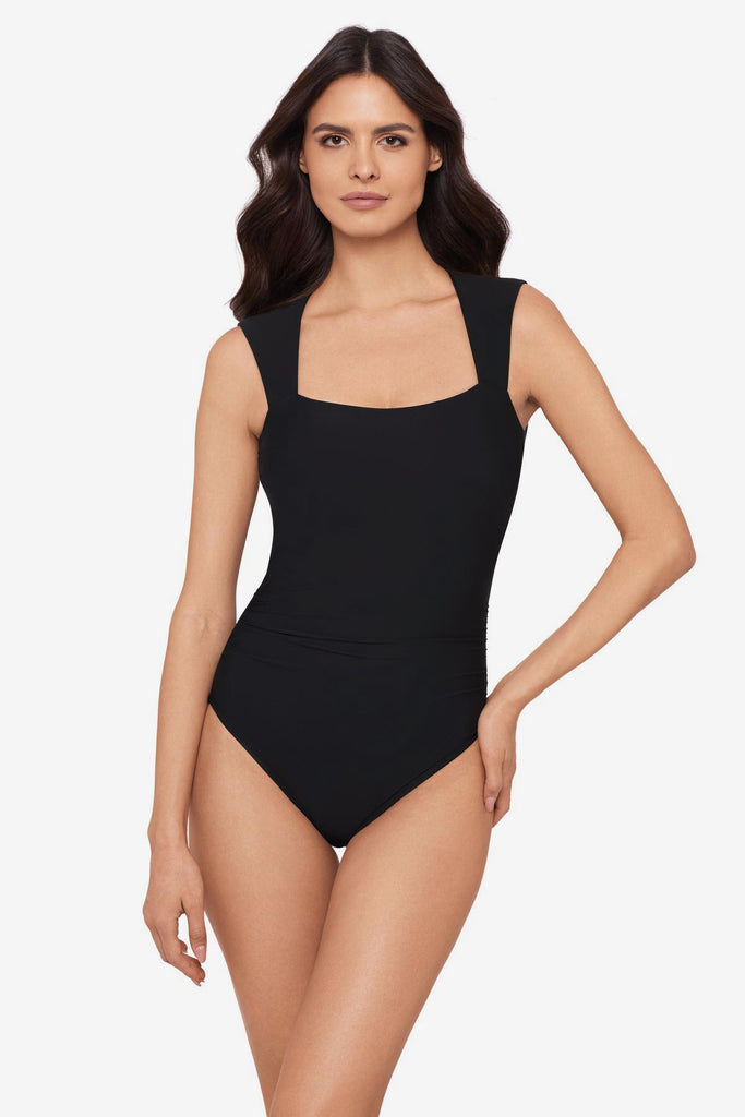 Woman wearing a black one-piece swimsuit with short sleeves