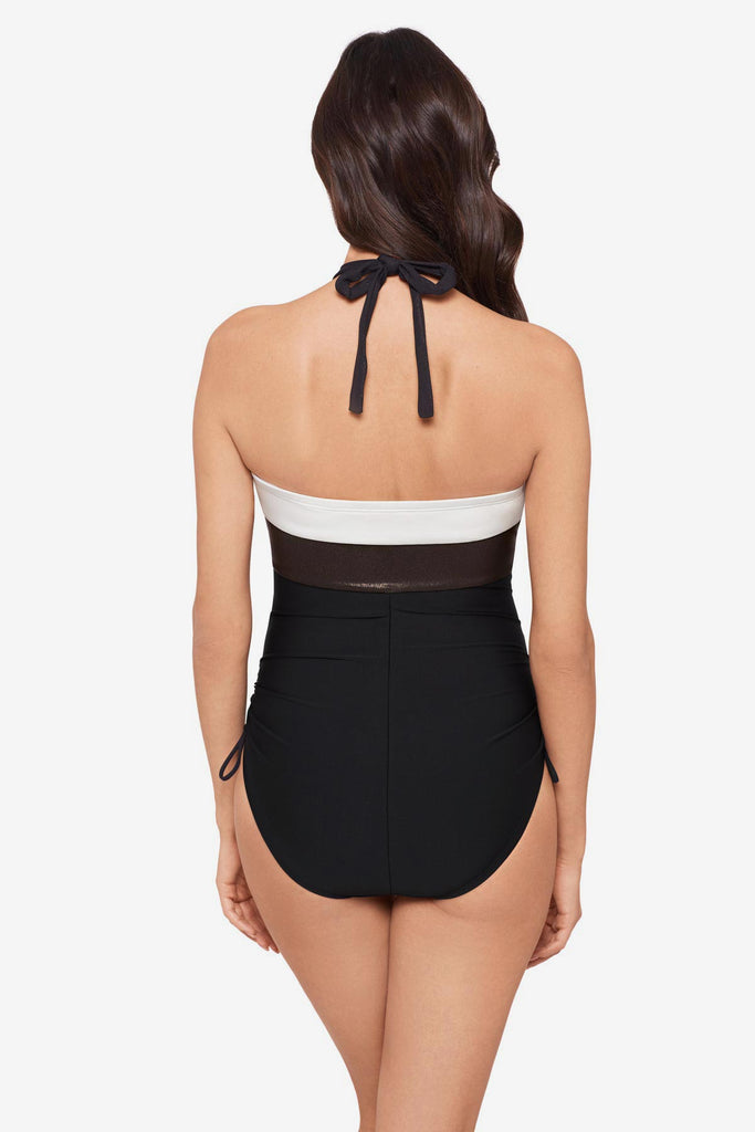 Woman turned away wearing a black halter top swimsuit with a white stripe along the chest