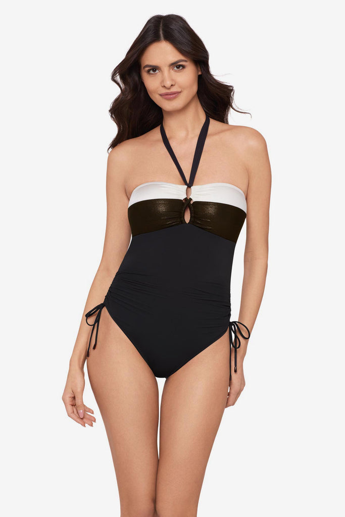 Woman wearing a black halter top swimsuit with a white stripe along the chest